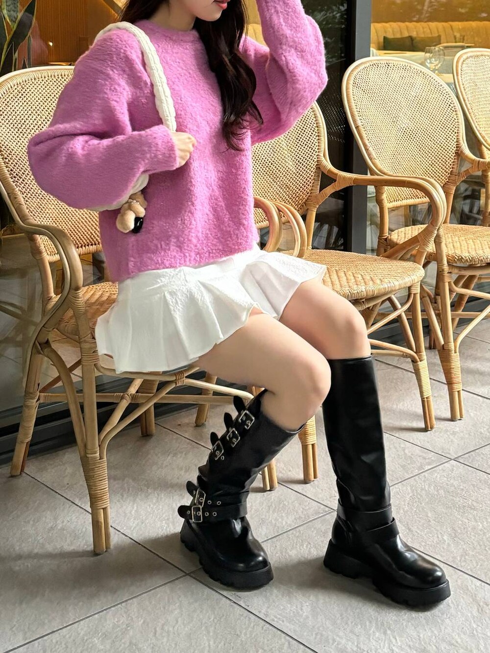 ホワイト系のショルダーバッグ、ピンク系のニット/セーター、ホワイト系のスカートを着用したレディースの秋コーディネートの2枚目の写真