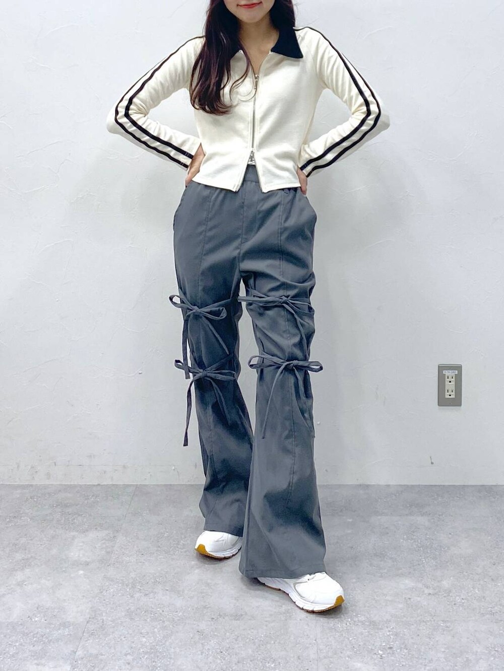 グレー系のスラックス、ベージュ系のTシャツ/カットソーを着用したレディースの冬コーディネートの2枚目の写真