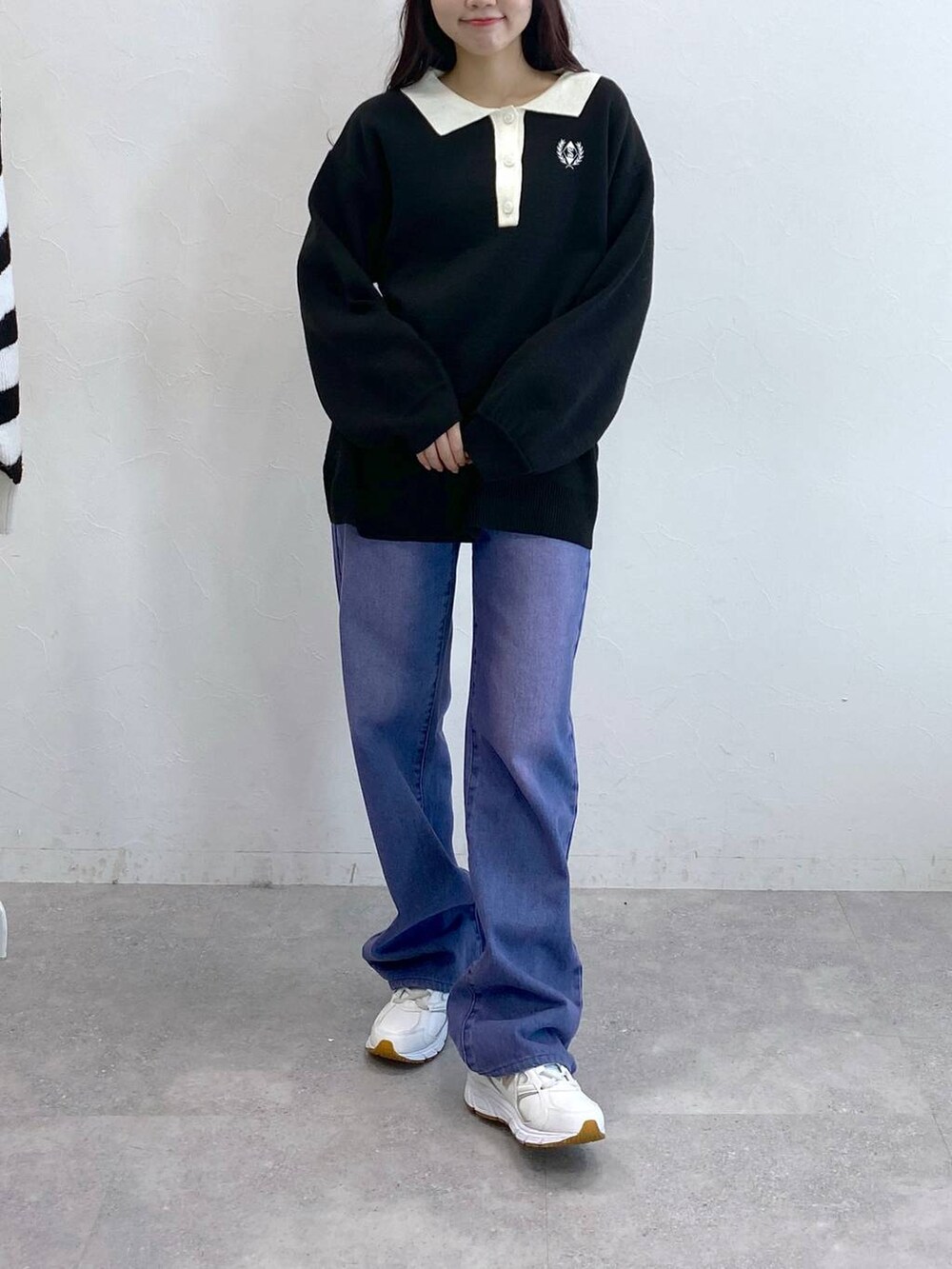 パープル系のデニムパンツ、ブラック系のニット/セーターを着用したレディースの冬コーディネートの2枚目の写真