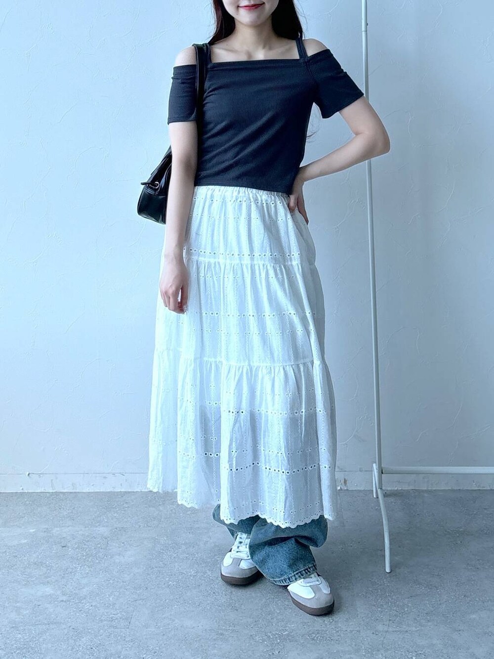 ブルー系のデニムパンツ、ベージュ系のスカート、グレー系のTシャツ/カットソーを着用したレディースの春コーディネートの2枚目の写真