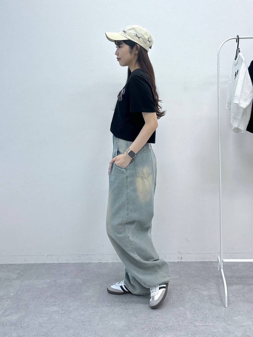 ブルー系のデニムパンツ、ブラック系のTシャツ/カットソー、ベージュ系のキャップを着用したレディースの春コーディネートの3枚目の写真