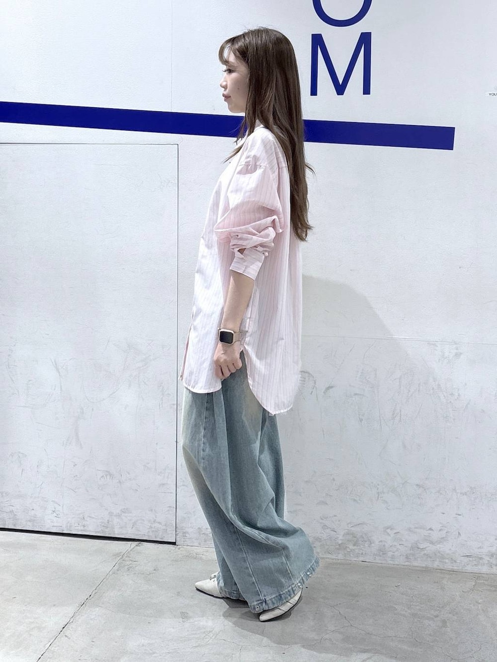 ブルー系のデニムパンツ、ホワイト系のパンプス、ピンク系のシャツ/ブラウスを着用したレディースの春コーディネートの3枚目の写真