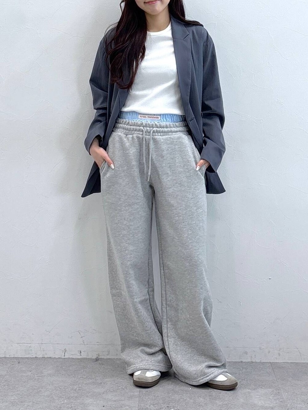 ブラック系のテーラードジャケット、ベージュ系のTシャツ/カットソー、グレー系のスウェットパンツを着用したレディースの春コーディネートの2枚目の写真