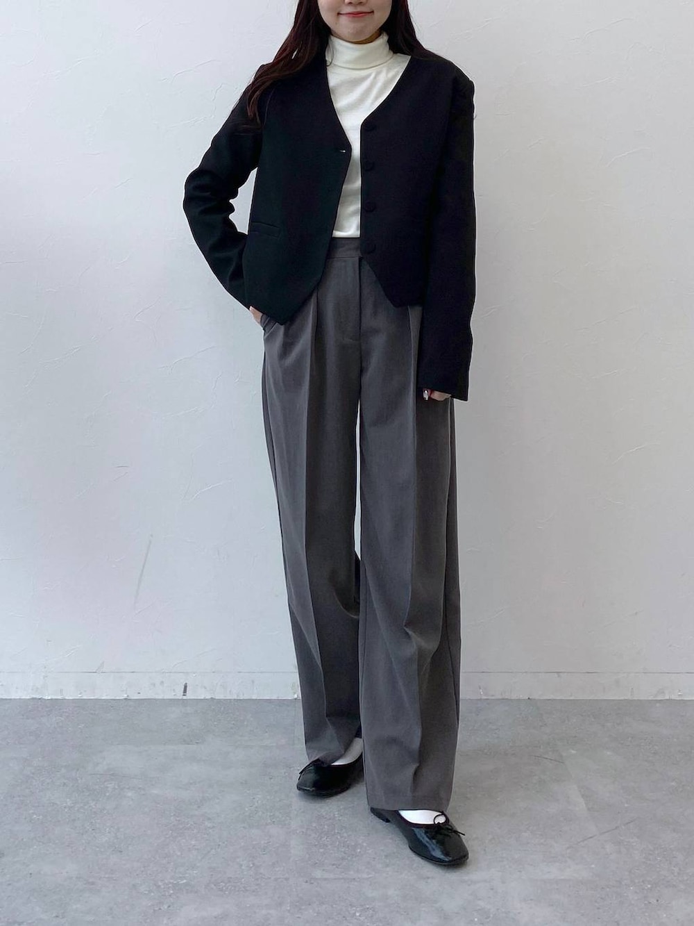 ブラック系のバレエシューズ、グレー系のスラックス、ブラック系のノーカラージャケットを着用したレディースの冬コーディネートの4枚目の写真