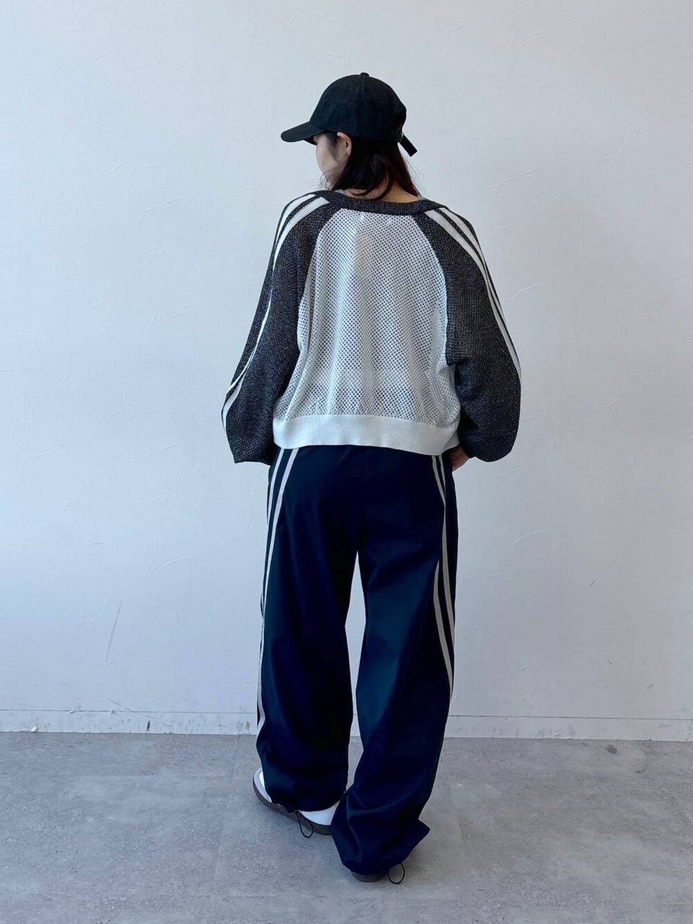 ブルー系のその他パンツ、グレー系のタンクトップ、ブラック系のキャップを着用したレディースの冬コーディネートの4枚目の写真