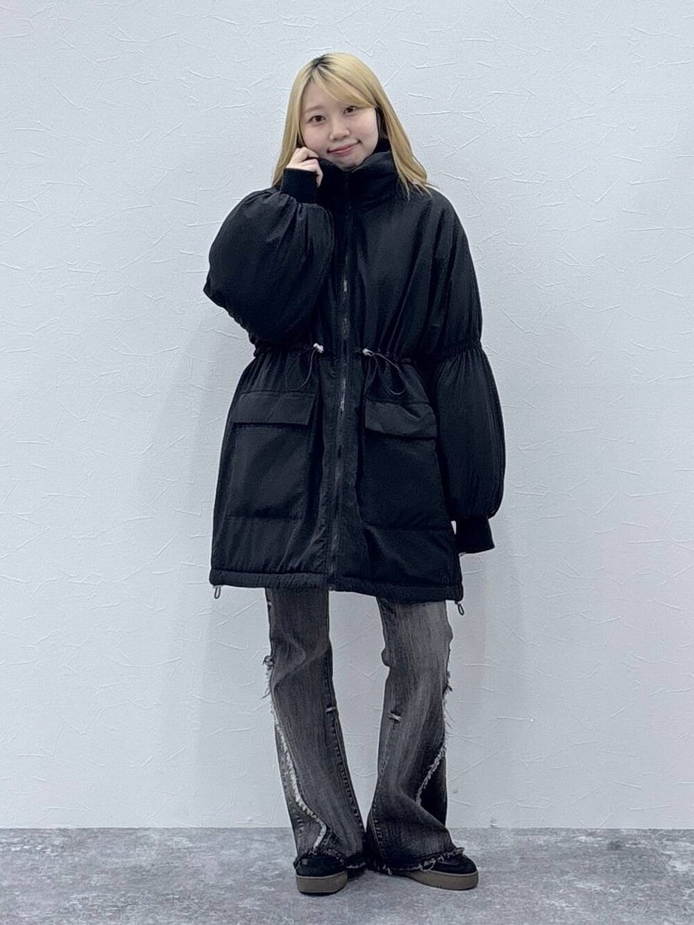 ブラック系のダウンジャケット/コート、レッド系のニット/セーター、ブラック系のデニムパンツを着用したレディースの秋コーディネートの2枚目の写真