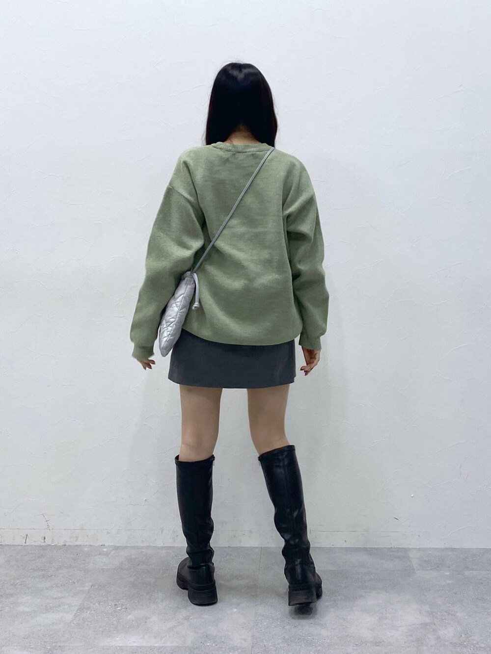 グリーン系のニット/セーター、グレー系のショルダーバッグ、グレー系のスカートを着用したレディースの冬コーディネートの4枚目の写真