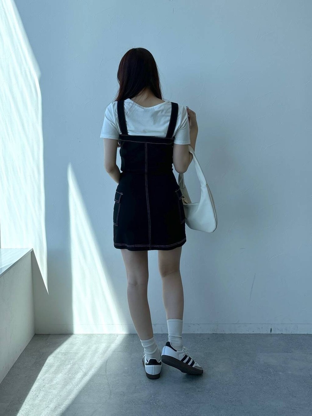 ブラック系のワンピース、ホワイト系のTシャツ/カットソーを着用したレディースの春コーディネートの4枚目の写真