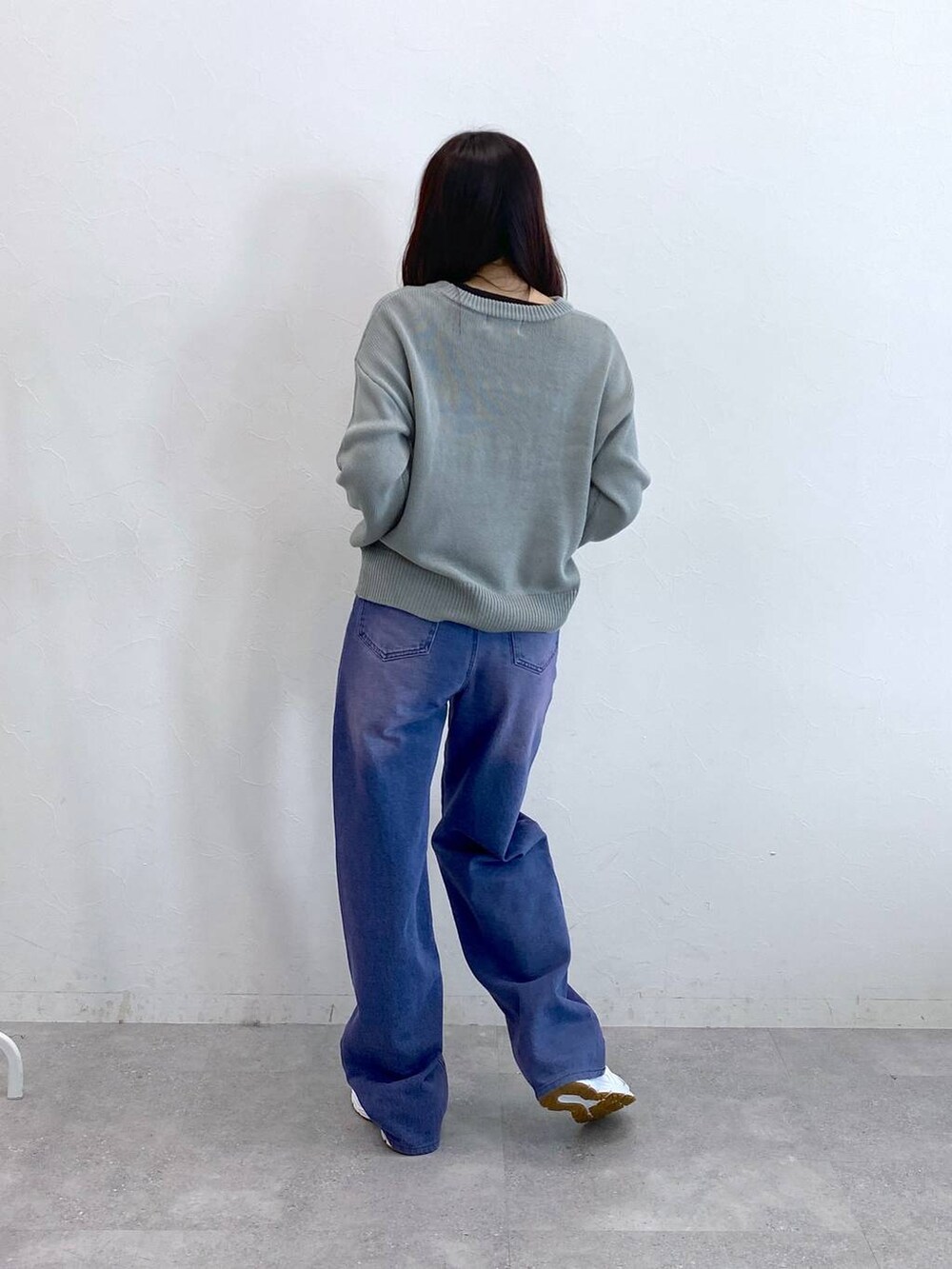 パープル系のデニムパンツ、グレー系のニット/セーターを着用したレディースの冬コーディネートの5枚目の写真