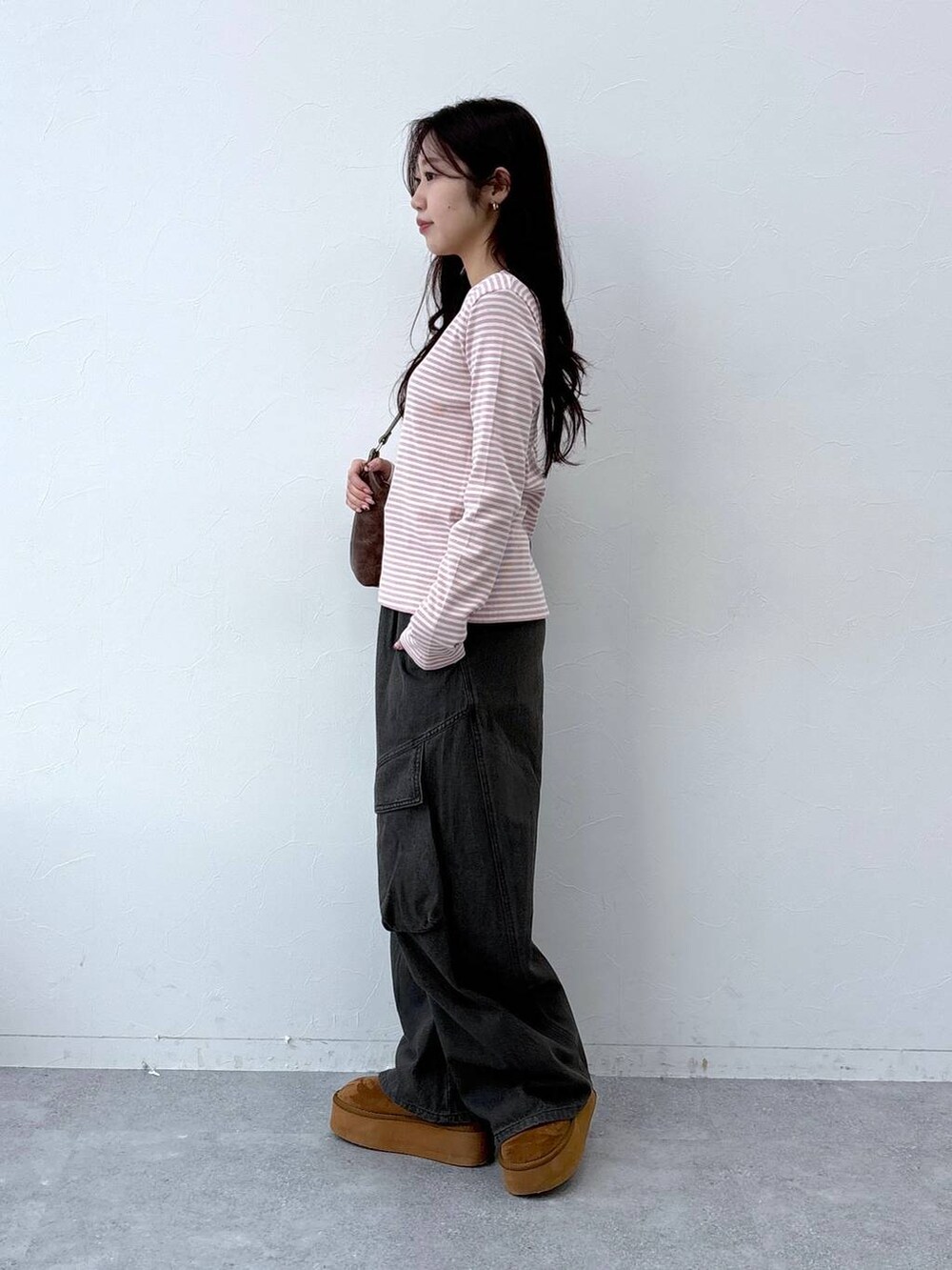 ブラウン系のハンドバッグを着用したレディースの春コーディネートの3枚目の写真