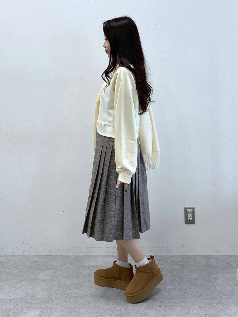 ブラウン系のスカート、ベージュ系のスウェット、ホワイト系のマフラーを着用したレディースの秋コーディネートの3枚目の写真