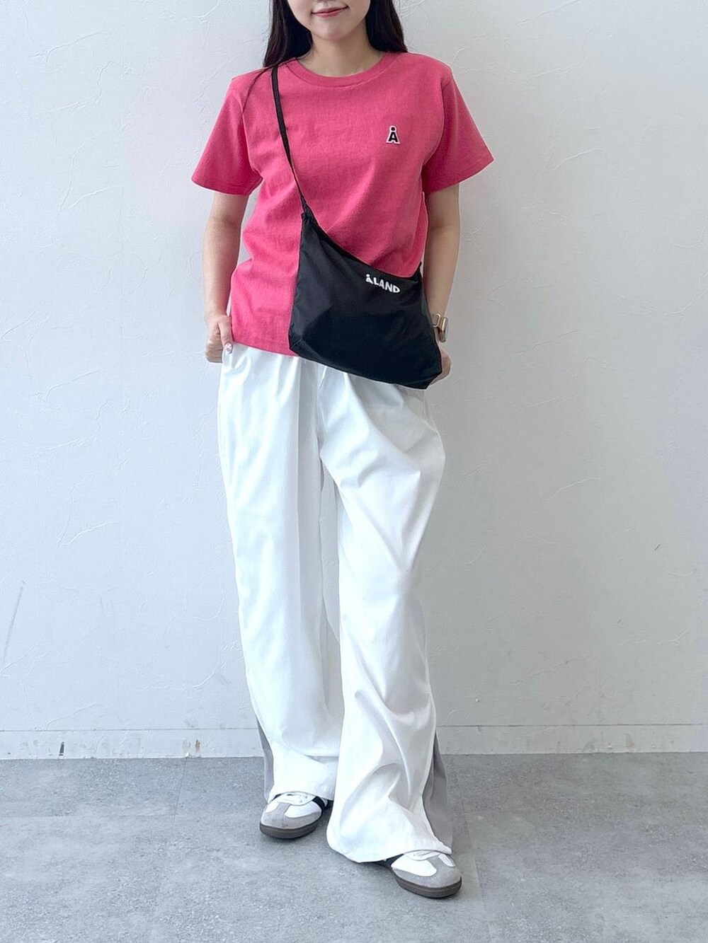 ベージュ系のカーゴパンツ、ピンク系のTシャツ/カットソー、ブラック系のショルダーバッグを着用したレディースの春コーディネートの3枚目の写真