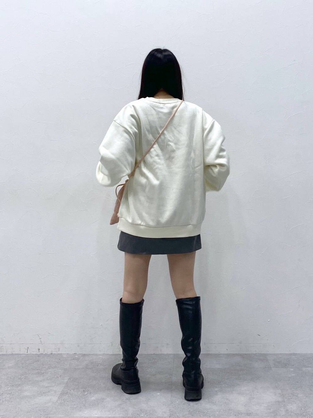 ピンク系のショルダーバッグ、グレー系のスカート、ベージュ系のスウェットを着用したレディースの冬コーディネートの4枚目の写真