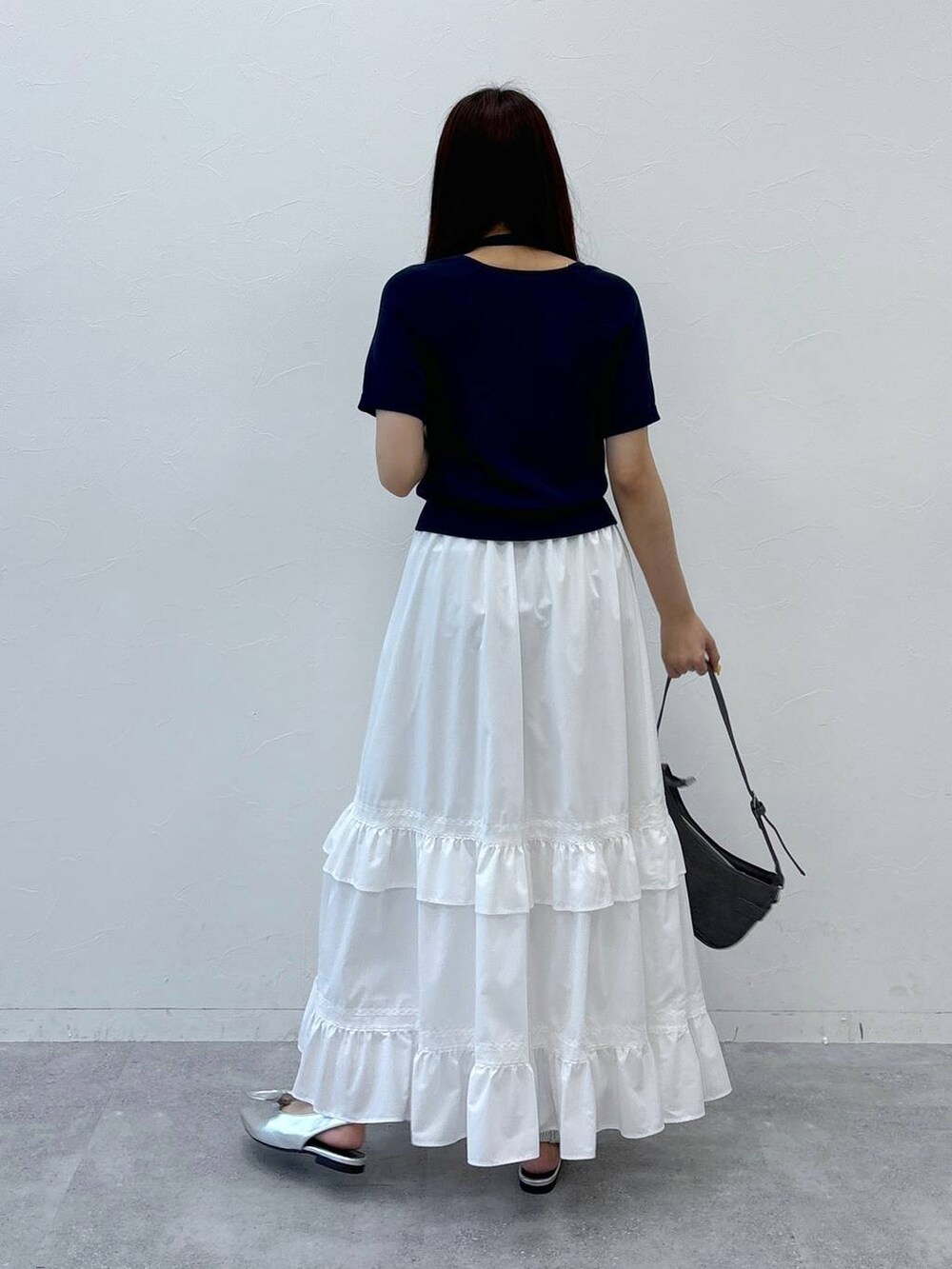 ホワイト系のスカート、ブラック系のトートバッグ、その他のサンダルを着用したレディースの夏コーディネートの5枚目の写真