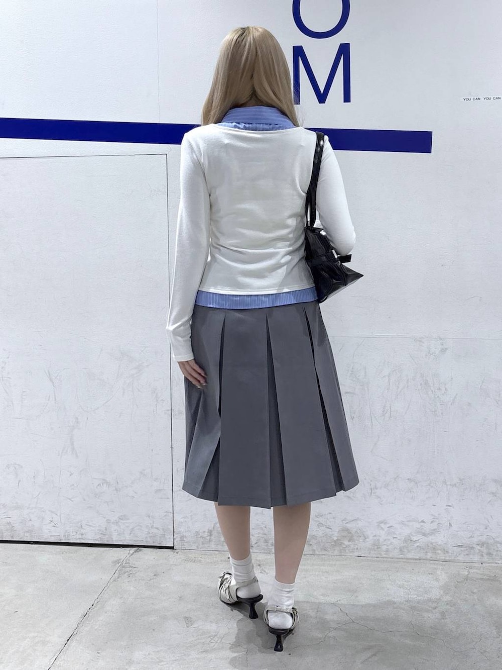 ホワイト系のパンプス、ブラック系のショルダーバッグ、ベージュ系のカーディガン/ボレロを着用したレディースの冬コーディネートの4枚目の写真