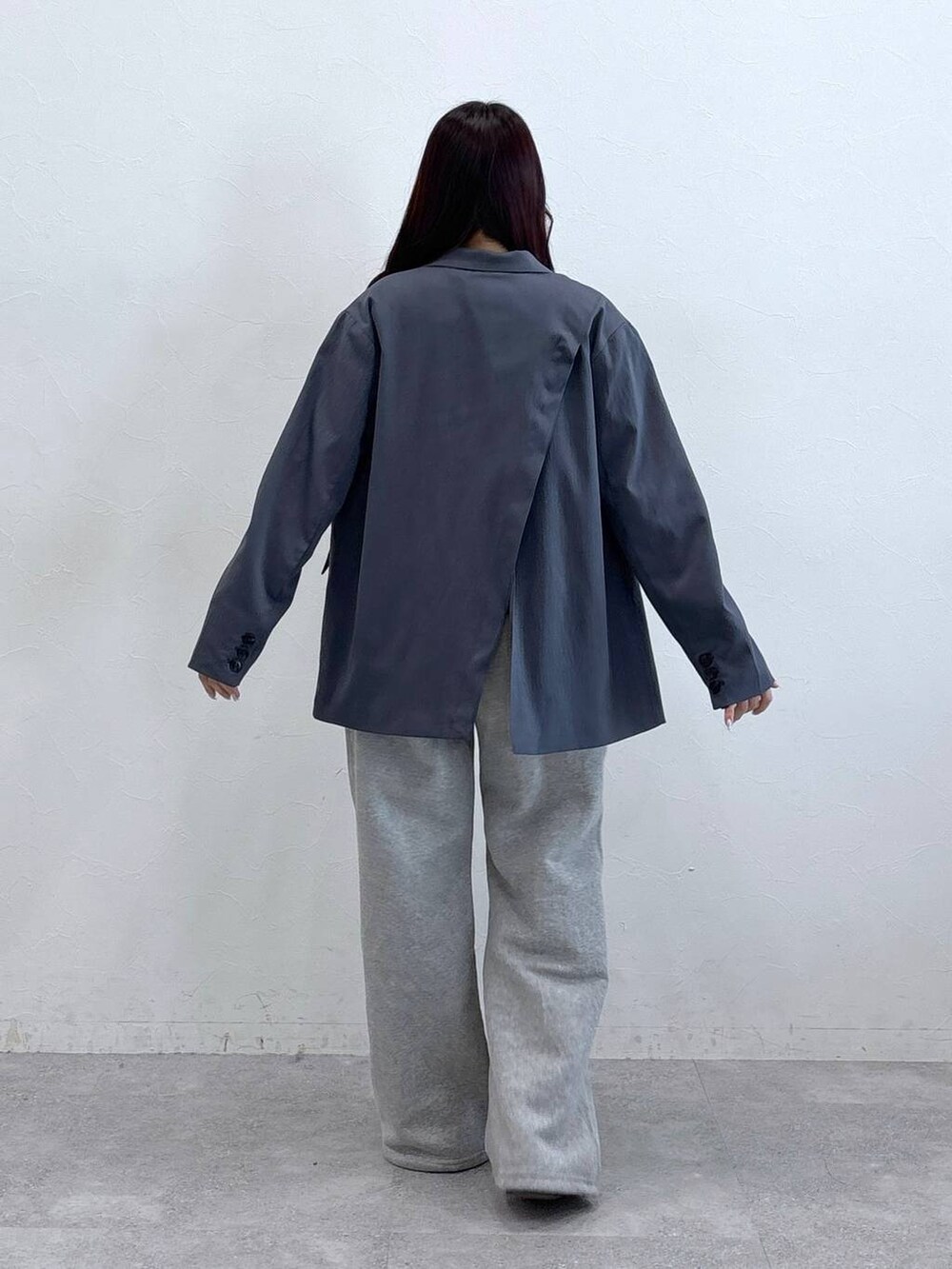 ブラック系のテーラードジャケット、ベージュ系のTシャツ/カットソー、グレー系のスウェットパンツを着用したレディースの春コーディネートの4枚目の写真