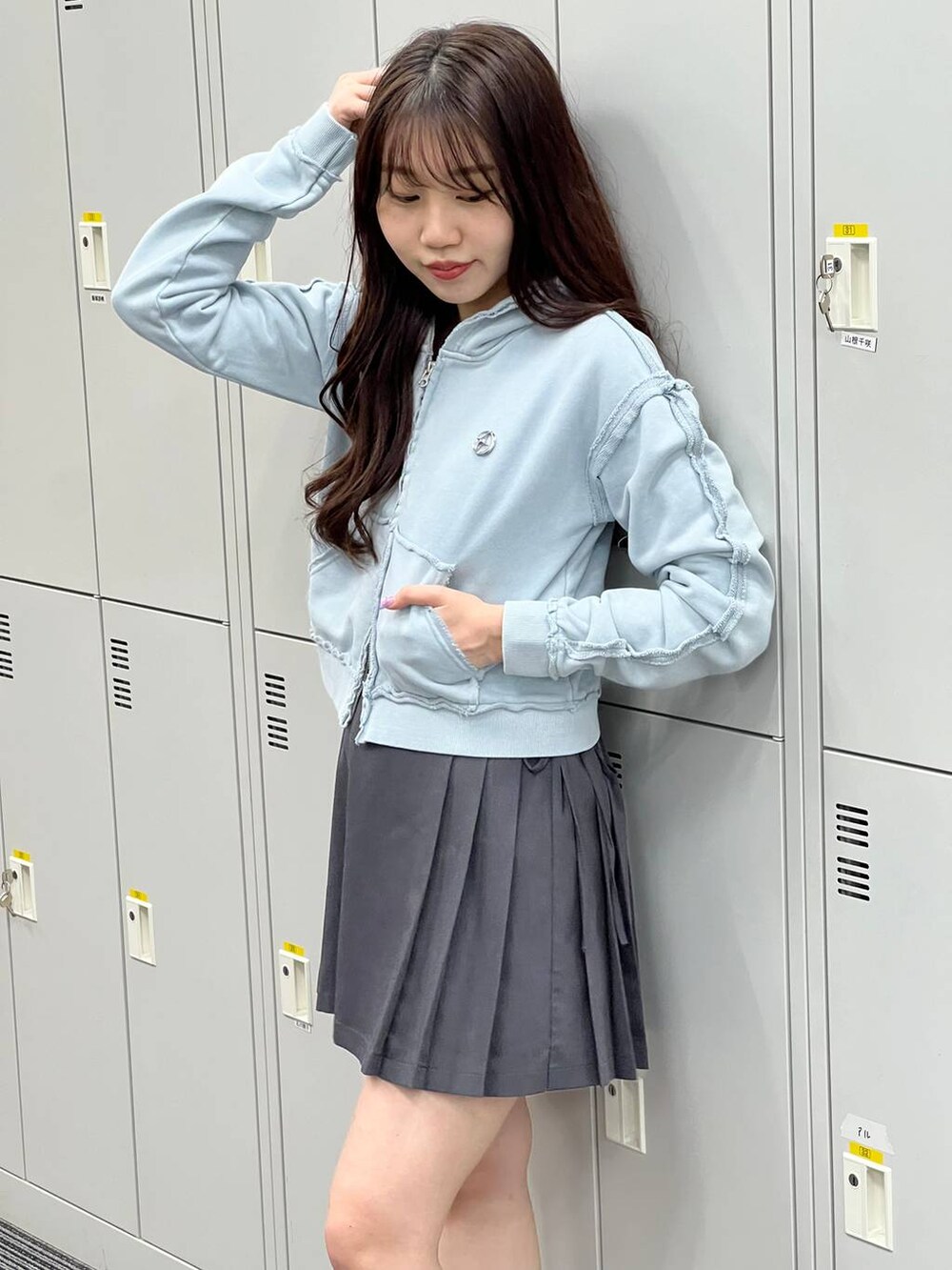 グレー系のスカート、ブルー系のパーカーを着用したレディースの春コーディネートの2枚目の写真