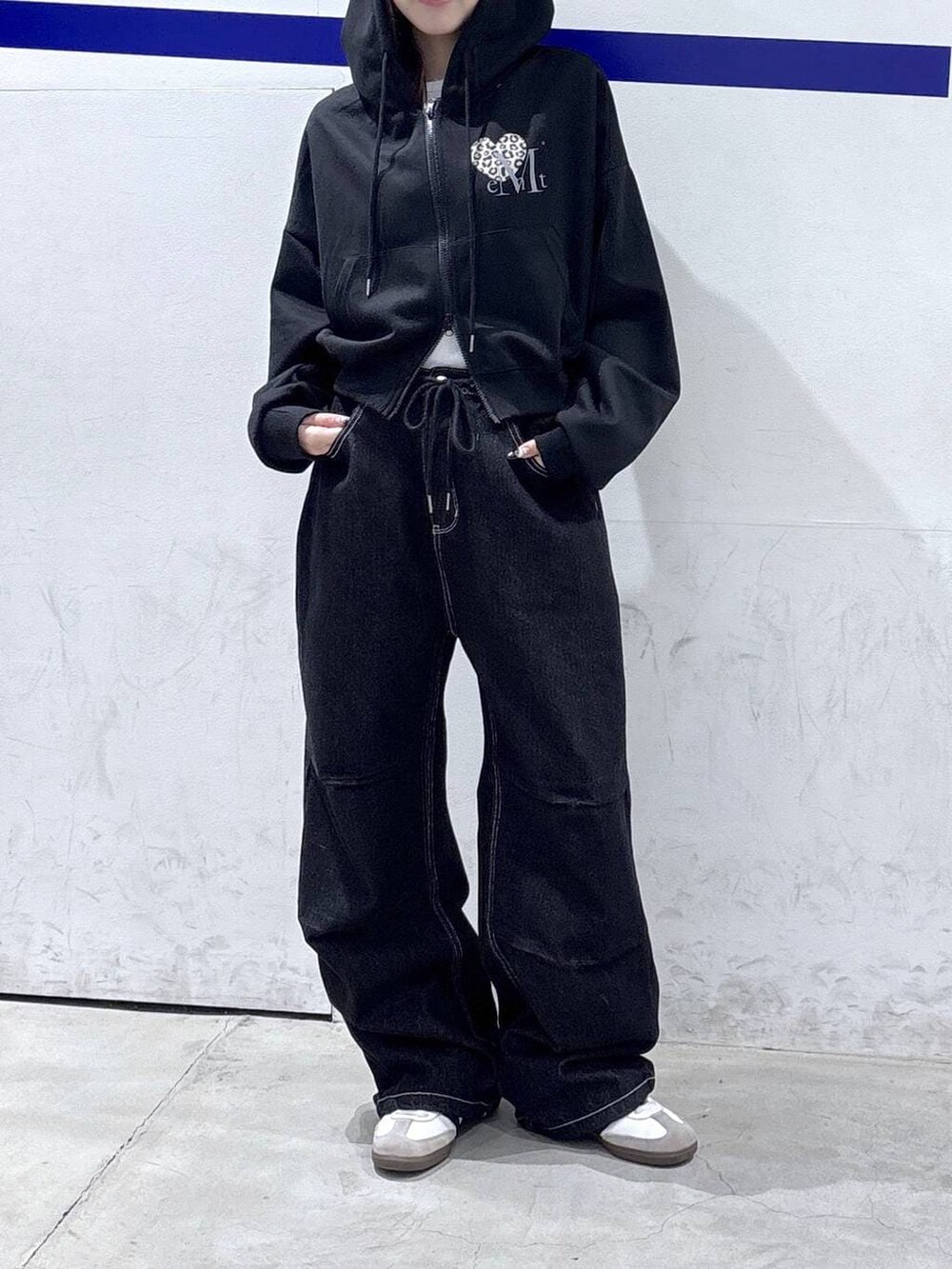 ブラック系のパーカー、ブラック系のデニムパンツを着用したレディースの春コーディネートの2枚目の写真