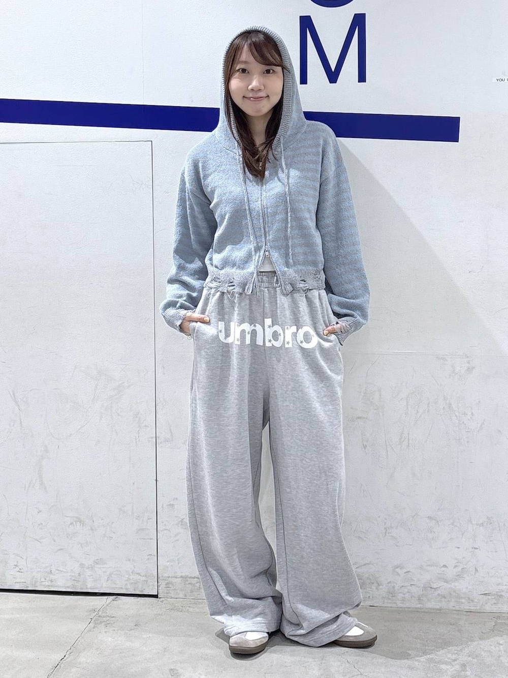 グレー系のスウェットパンツ、ブルー系のニット/セーターを着用したレディースの秋コーディネートの2枚目の写真