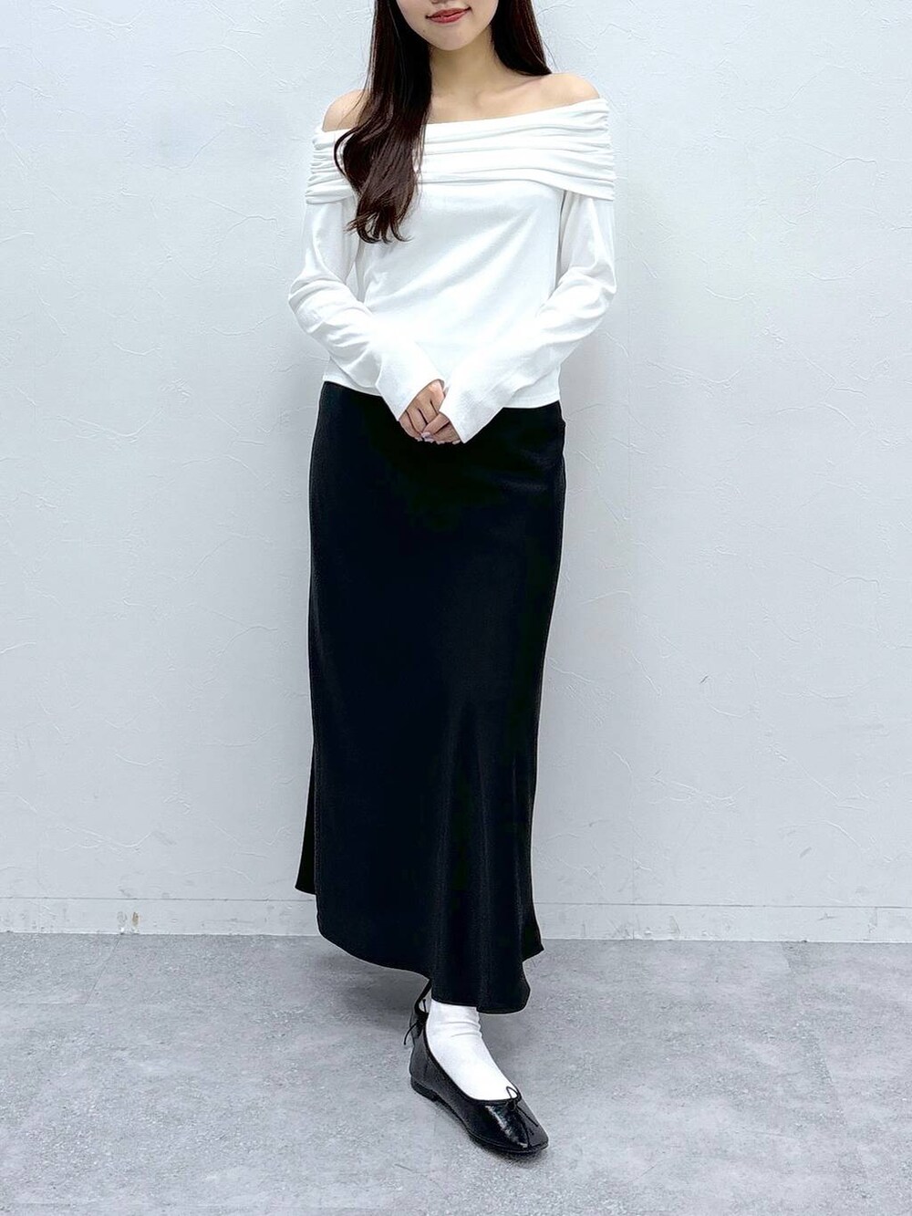 ブラック系のスカート、ホワイト系のTシャツ/カットソーを着用したレディースの春コーディネートの2枚目の写真