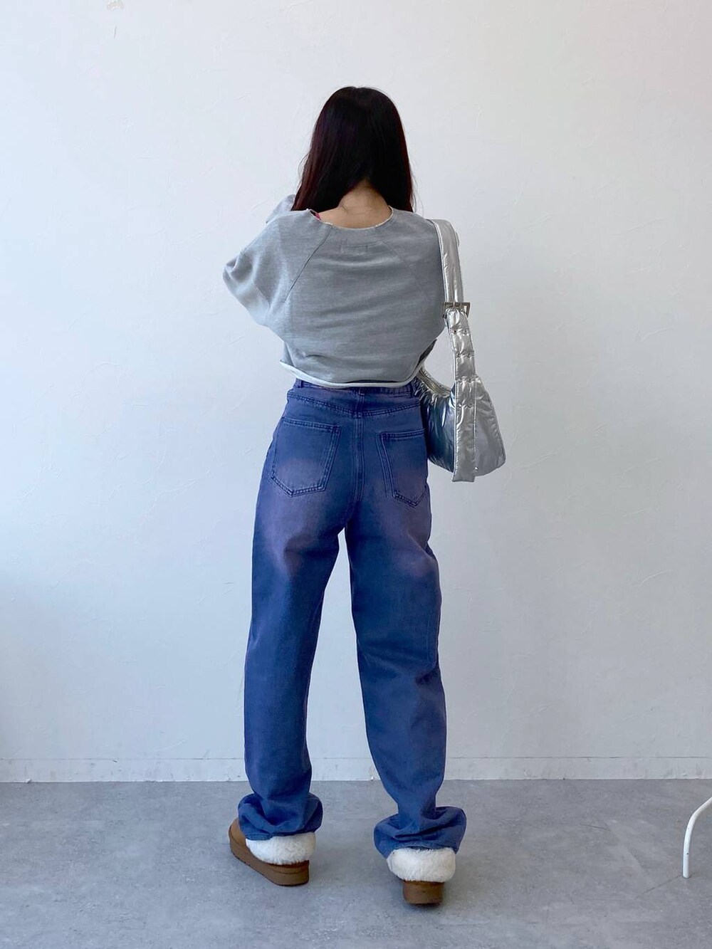 パープル系のデニムパンツ、その他のショルダーバッグ、グレー系のTシャツ/カットソーを着用したレディースの冬コーディネートの5枚目の写真