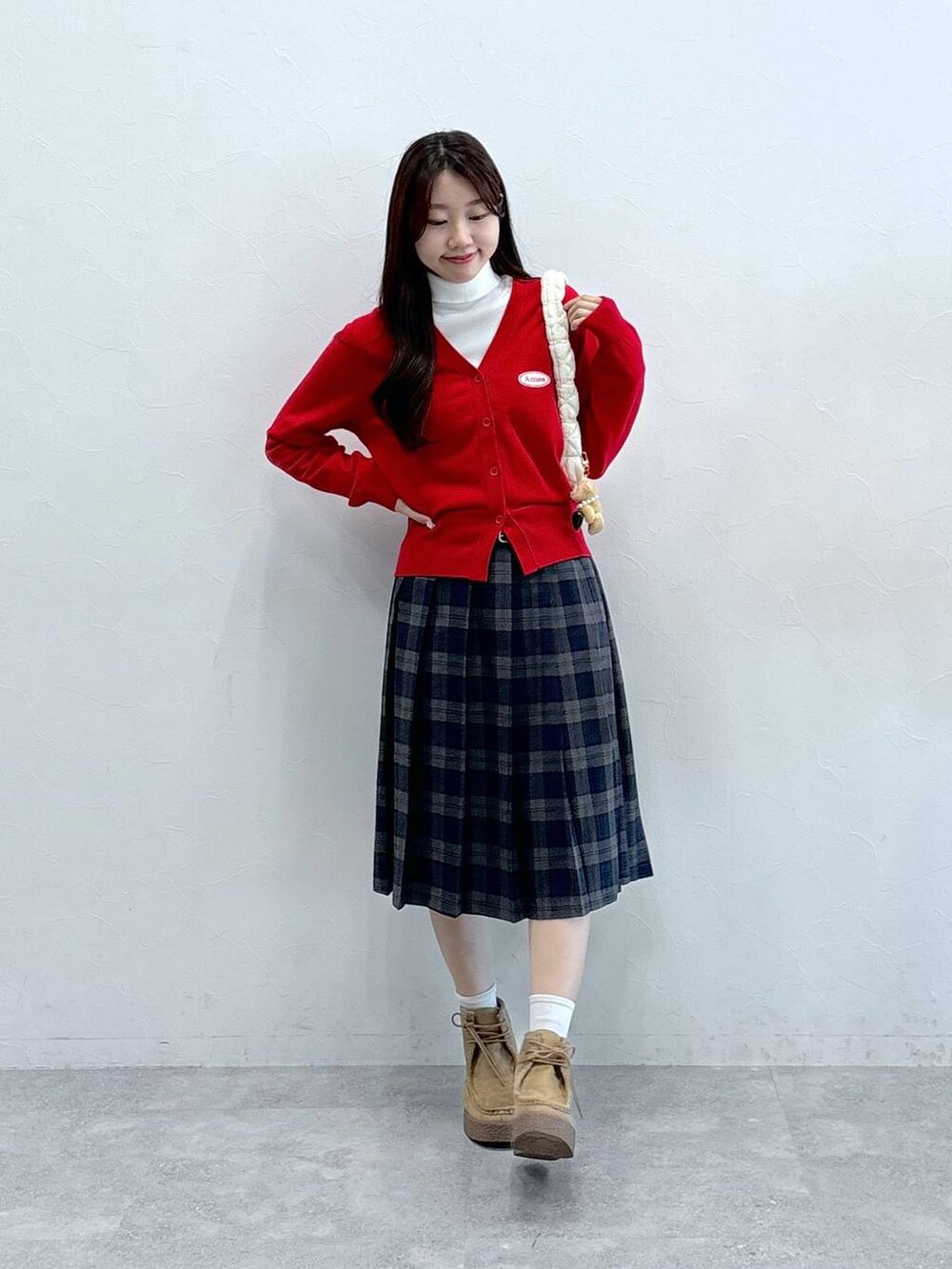 ホワイト系のショルダーバッグ、ホワイト系のニット/セーター、ベージュ系のブーツを着用したレディースの秋コーディネートの2枚目の写真