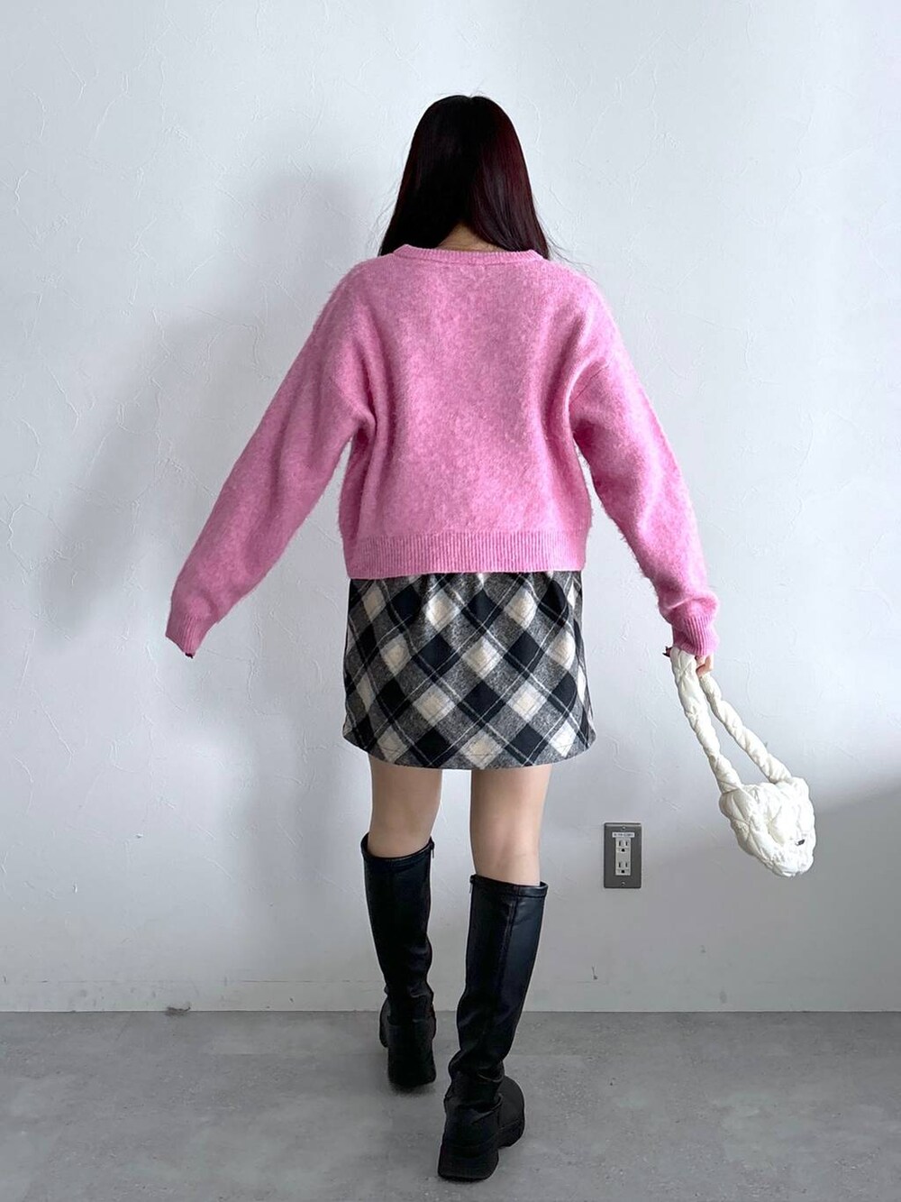 ホワイト系のショルダーバッグ、ブラック系のスカート、ピンク系のニット/セーターを着用したレディースの冬コーディネートの4枚目の写真