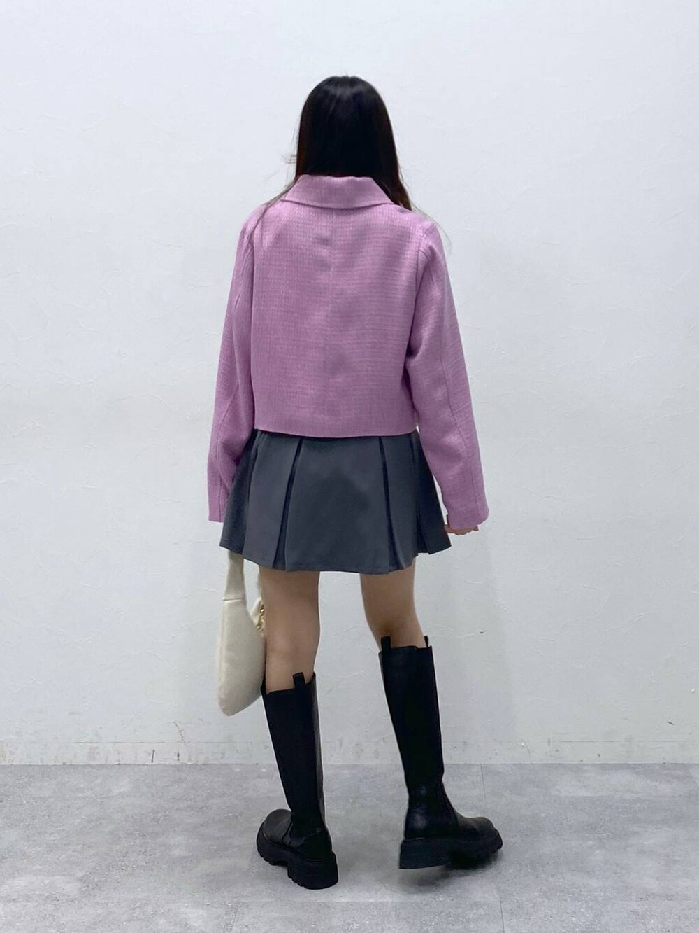 ブラック系のブーツ、ベージュ系のTシャツ/カットソー、グレー系のスカートを着用したレディースの冬コーディネートの5枚目の写真