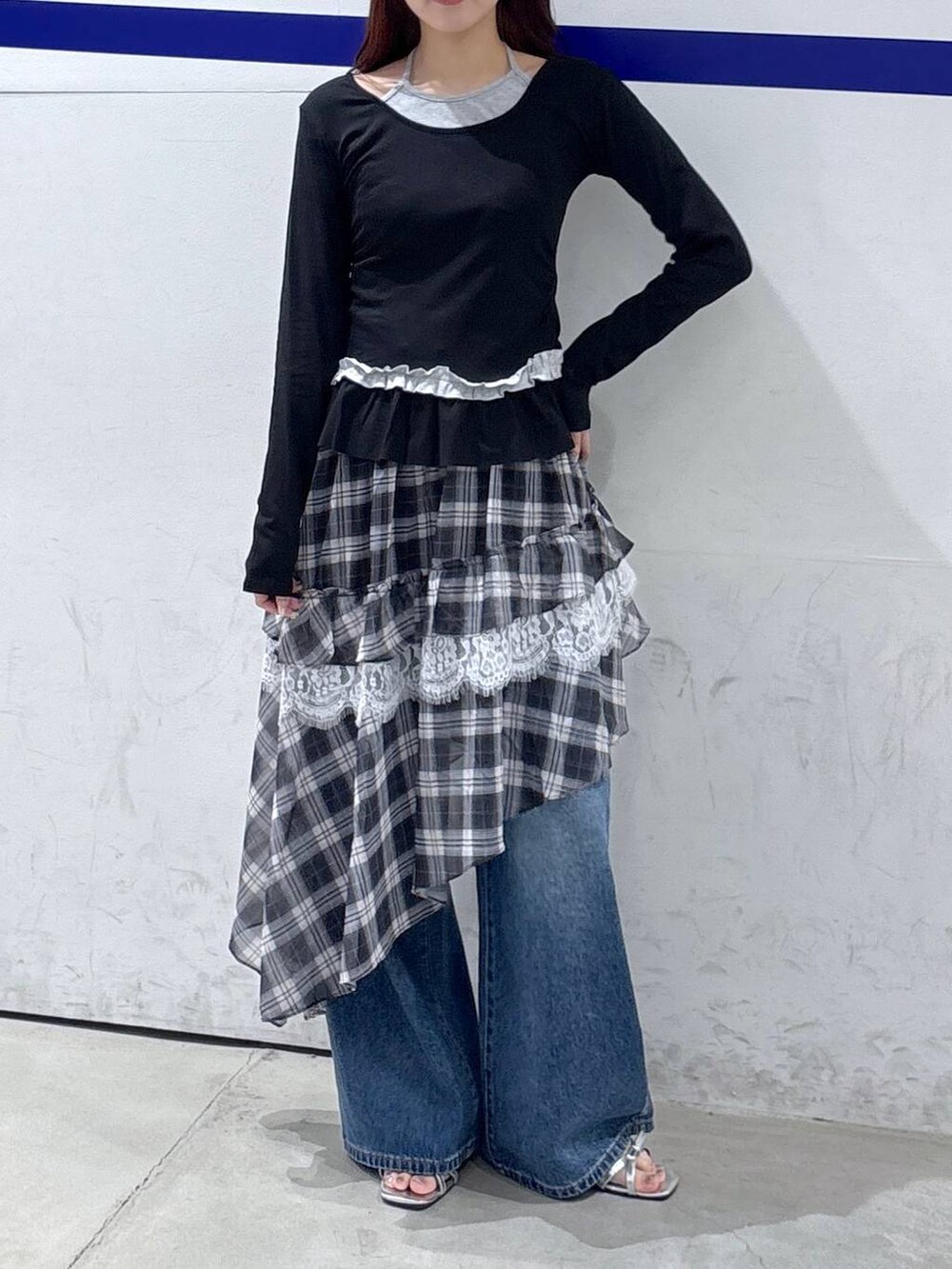 ブルー系のデニムパンツ、ブラック系のスカートを着用したレディースの夏コーディネートの2枚目の写真