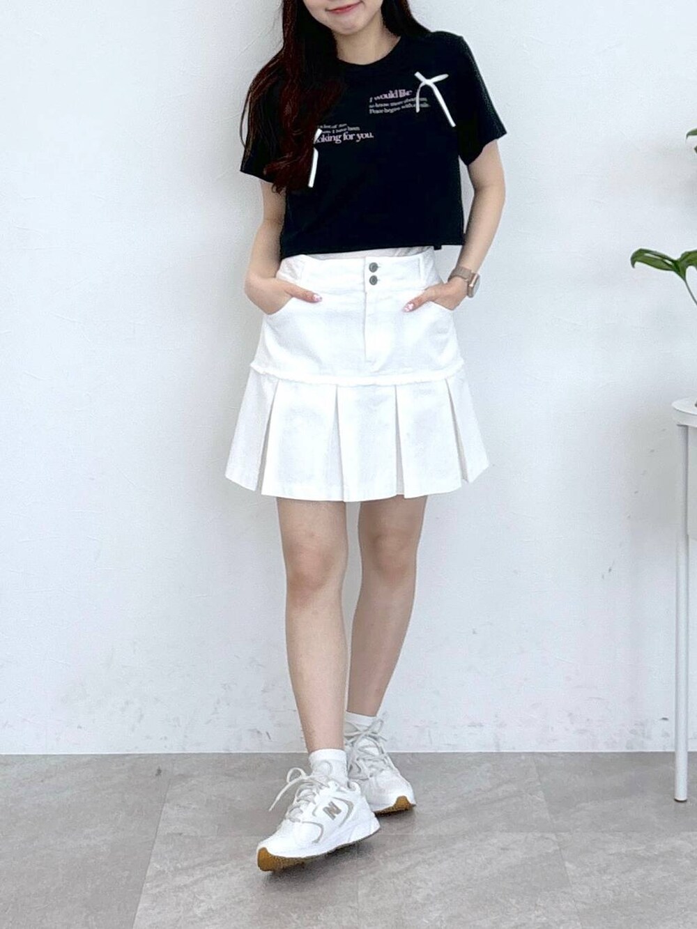 ホワイト系のデニムスカート、ブラック系のTシャツ/カットソーを着用したレディースの春コーディネートの2枚目の写真