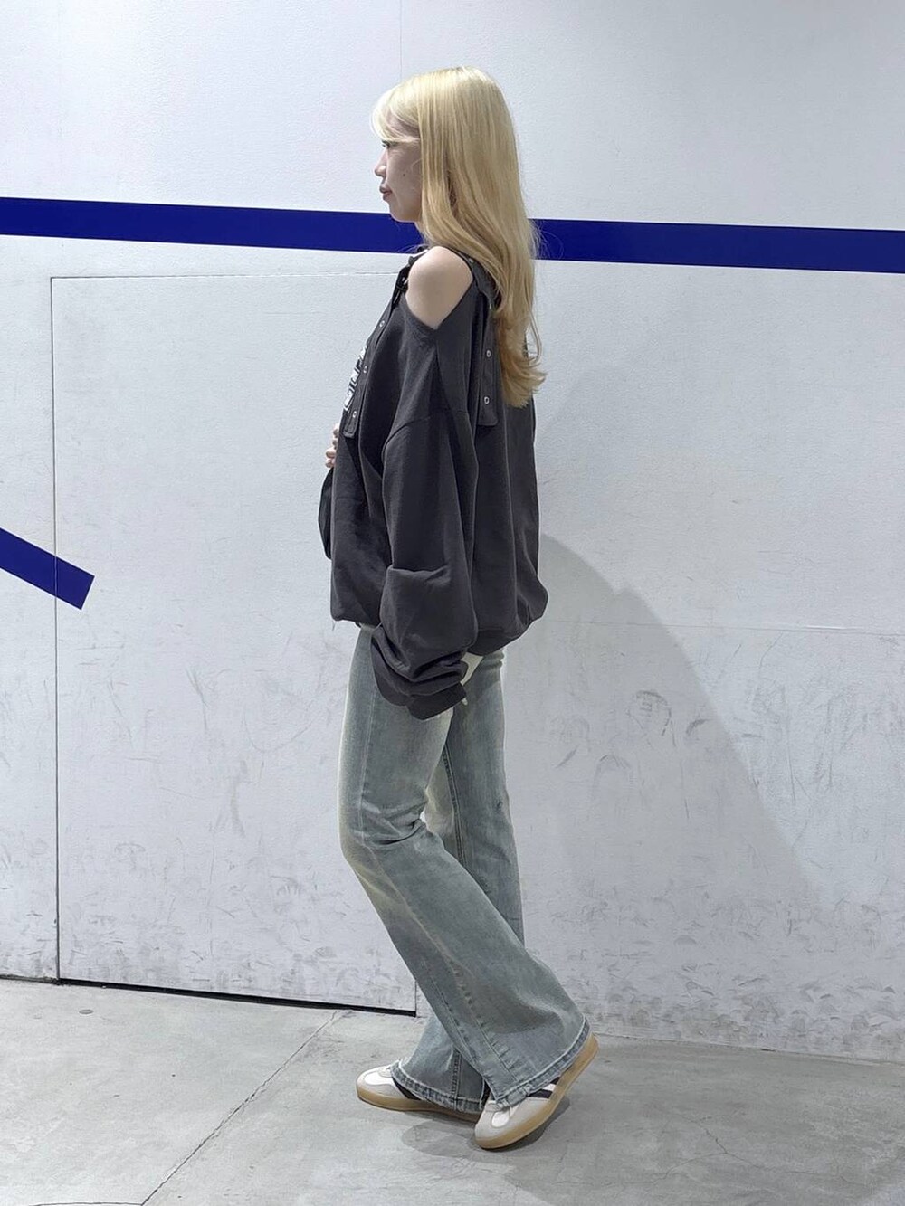 グレー系のスウェット、ブラック系のトートバッグ、ブルー系のデニムパンツを着用したレディースの秋コーディネートの3枚目の写真