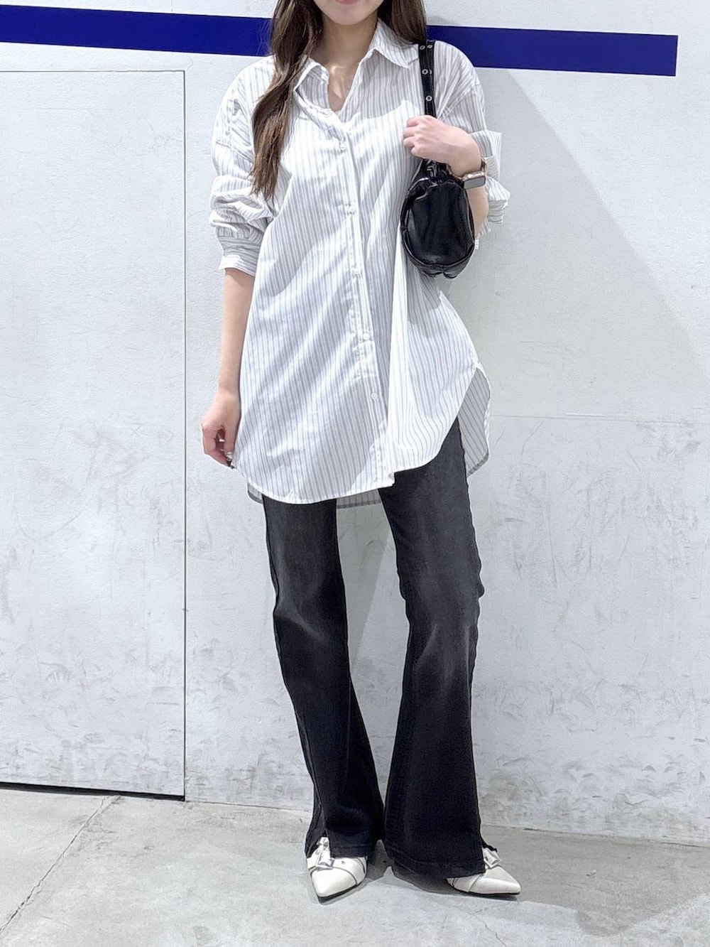 ブラック系のデニムパンツ、ホワイト系のパンプス、ホワイト系のシャツ/ブラウスを着用したレディースの春コーディネートの2枚目の写真