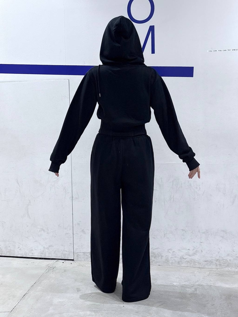 ブラック系のパーカー、ブラック系のスウェットパンツ、ブラック系のサンダルを着用したレディースの秋コーディネートの4枚目の写真
