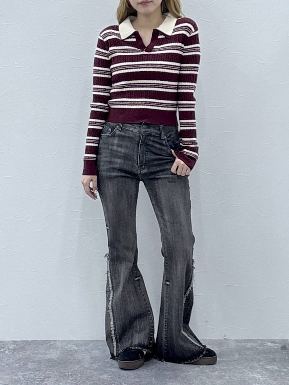 レッド系のニット/セーター、ブラック系のデニムパンツを着用したレディースの秋コーディネートの2枚目の写真