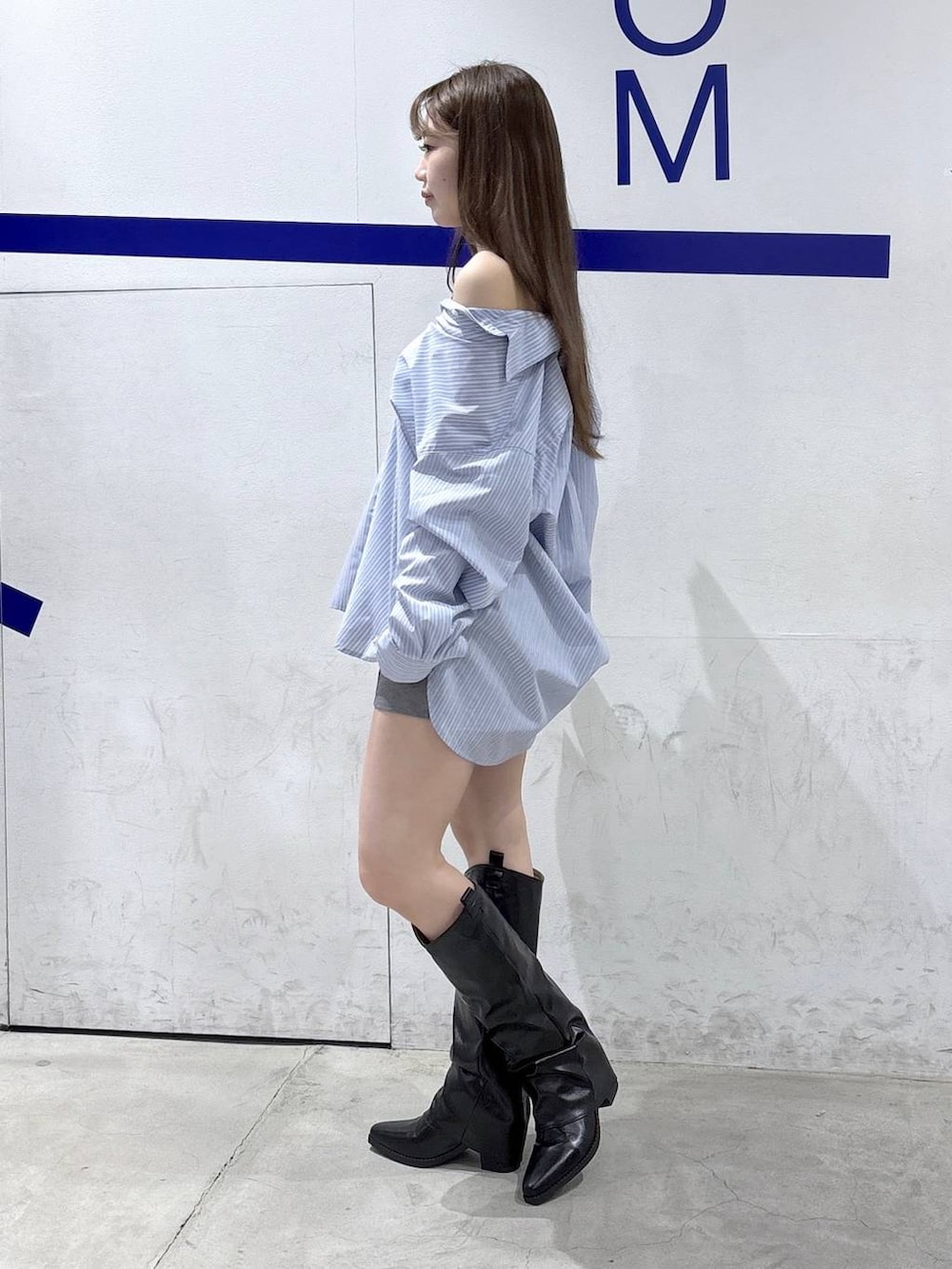 ブルー系のシャツ/ブラウス、グレー系のその他パンツ、ブラック系のブーツを着用したレディースの春コーディネートの3枚目の写真