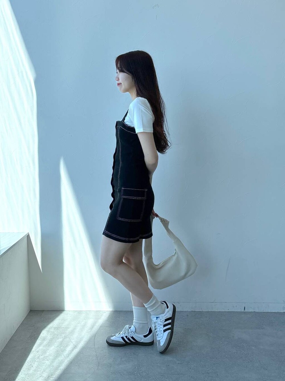 ブラック系のワンピース、ホワイト系のTシャツ/カットソーを着用したレディースの春コーディネートの3枚目の写真