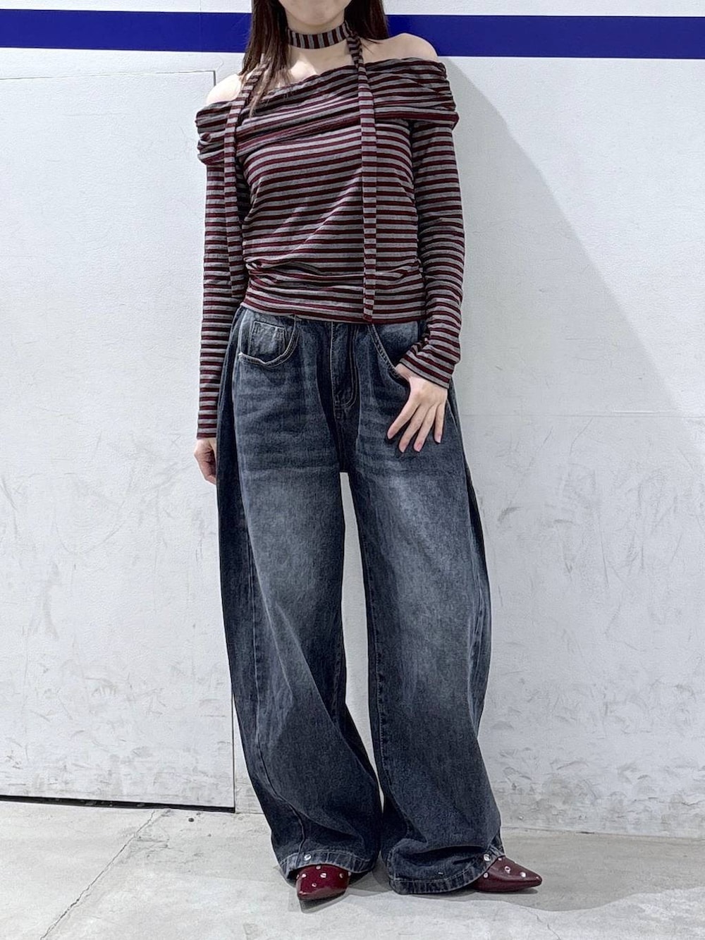 レッド系のTシャツ/カットソー、ブルー系のデニムパンツ、レッド系のサンダルを着用したレディースの秋コーディネートの2枚目の写真