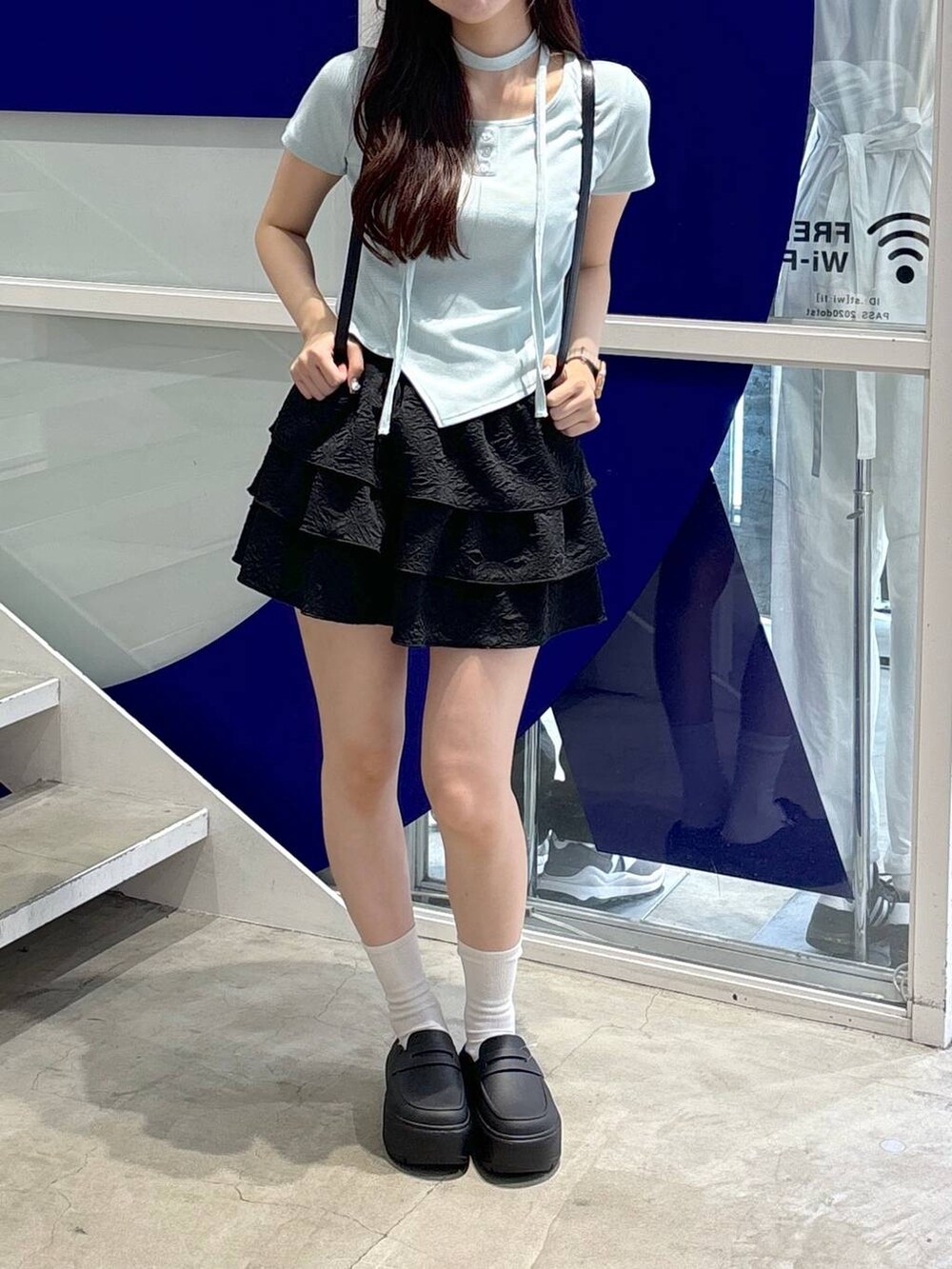 ブラック系のバックパック/リュック、ブルー系のTシャツ/カットソー、ブラック系のサンダルを着用したレディースの夏コーディネートの2枚目の写真