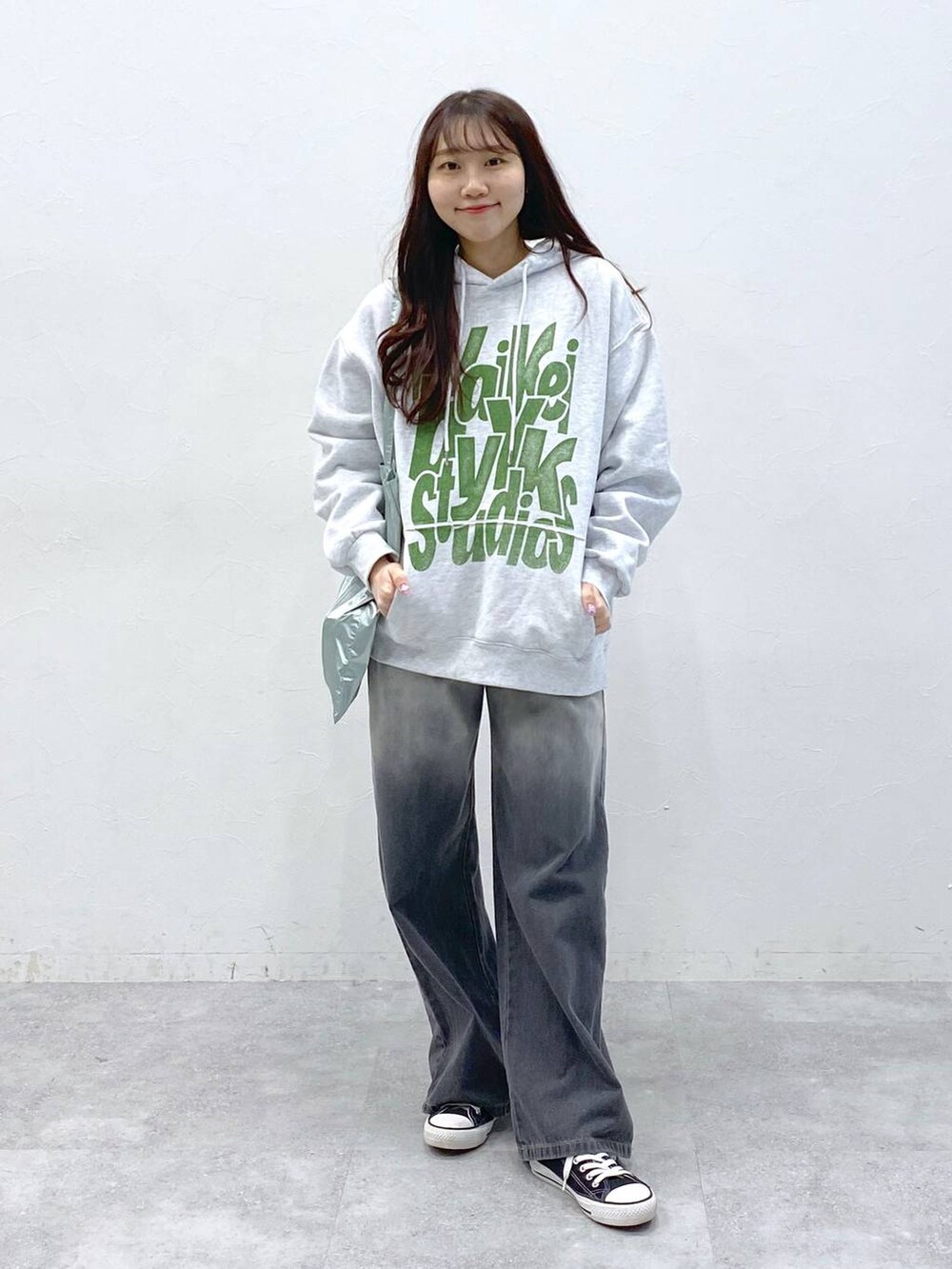 ブルー系のトートバッグ、ホワイト系のパーカー、ブラック系のデニムパンツを着用したレディースの春コーディネートの2枚目の写真