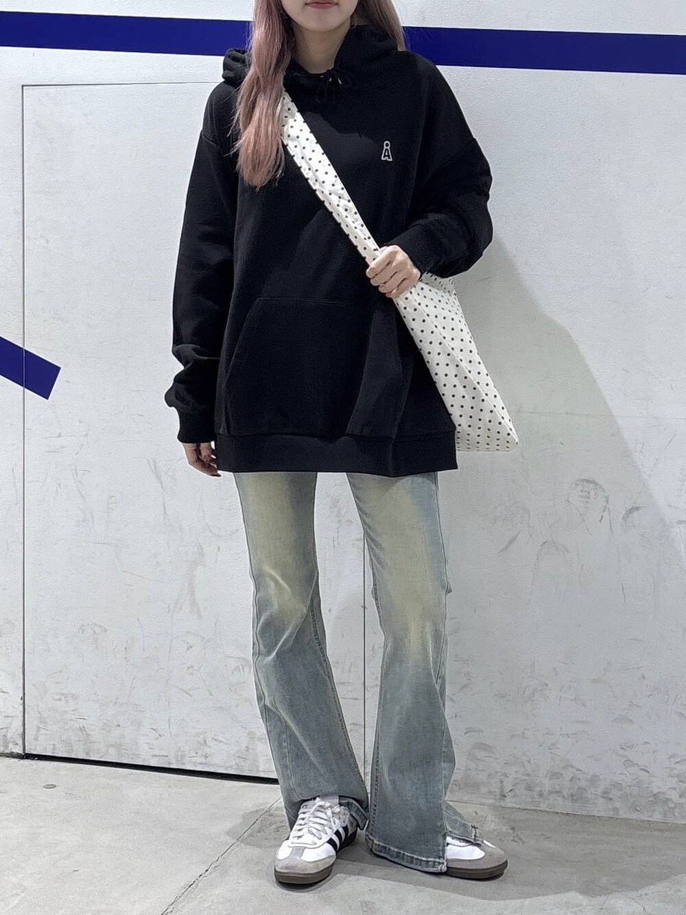 その他のトートバッグ、ブルー系のデニムパンツ、ブラック系のパーカーを着用したレディースの秋コーディネートの2枚目の写真