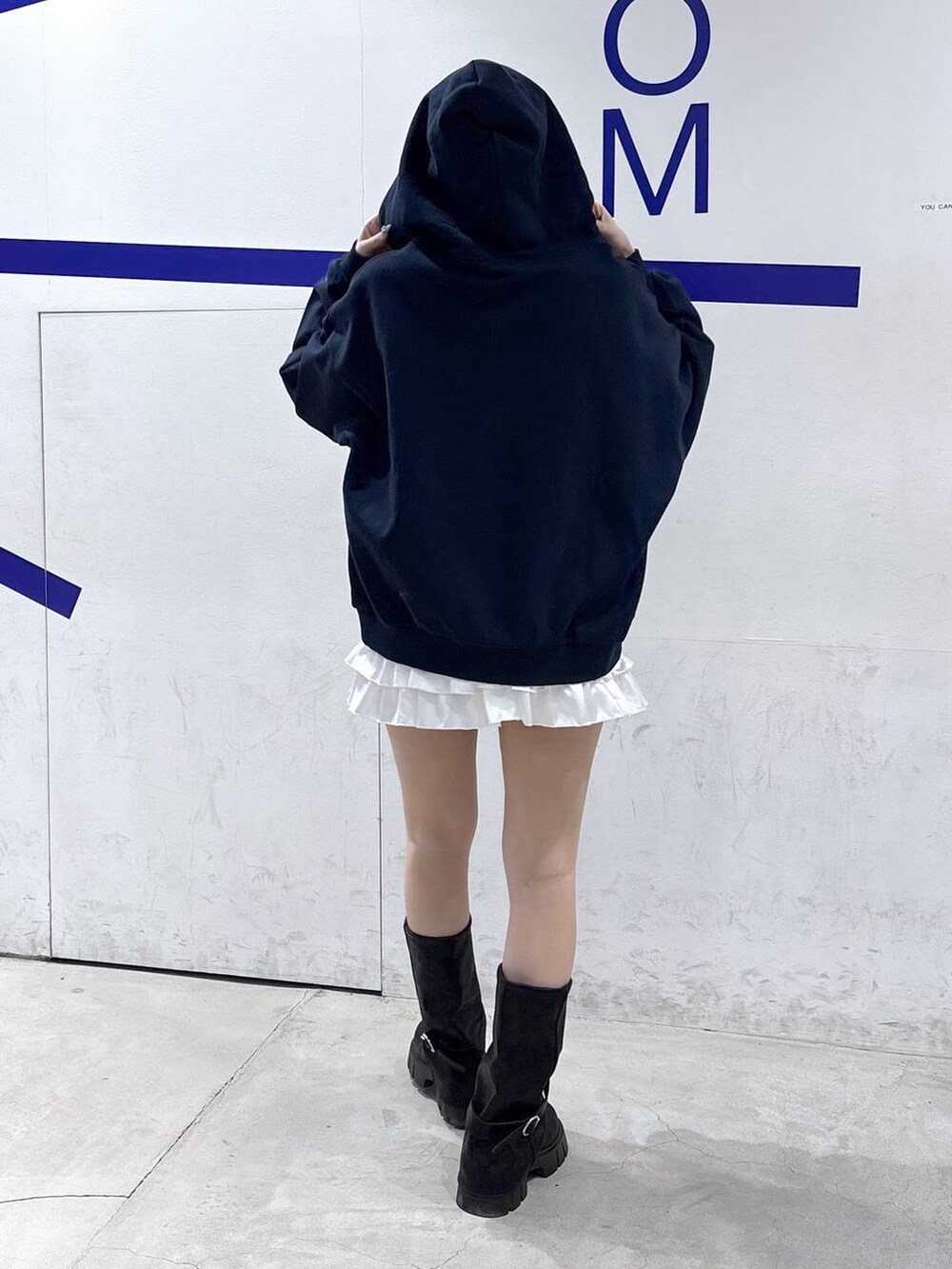 ブラック系のブーツ、ホワイト系のスカート、ブルー系のパーカーを着用したレディースの冬コーディネートの4枚目の写真