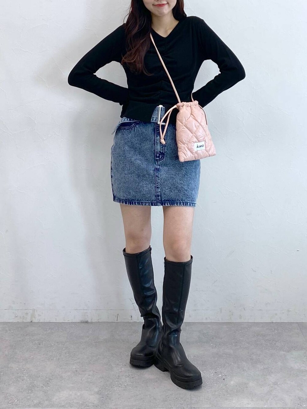 ブルー系のデニムスカート、ピンク系のショルダーバッグ、ブラック系のTシャツ/カットソーを着用したレディースの春コーディネートの2枚目の写真