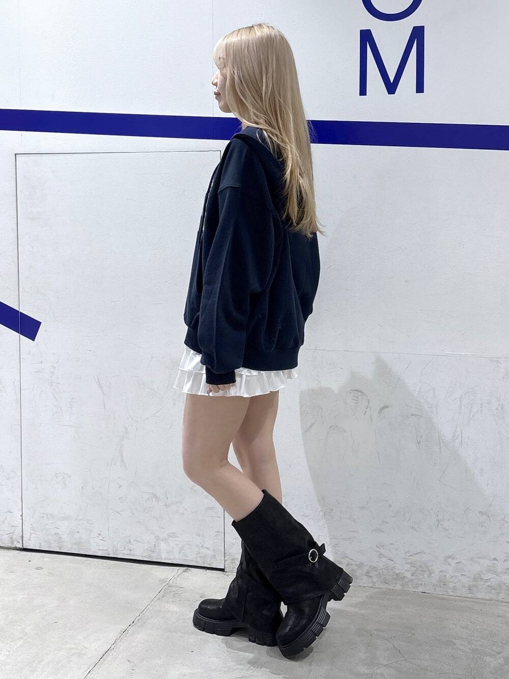 ブラック系のブーツ、ホワイト系のスカート、ブルー系のパーカーを着用したレディースの冬コーディネートの3枚目の写真