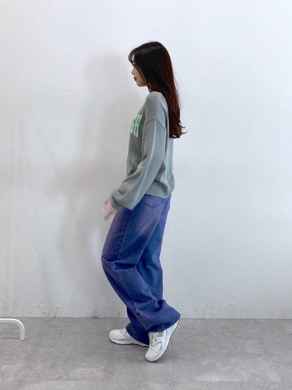 パープル系のデニムパンツ、グレー系のニット/セーターを着用したレディースの冬コーディネートの4枚目の写真