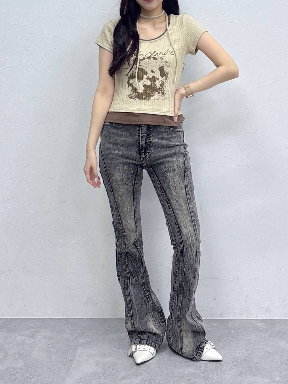 ベージュ系のサンダル、ベージュ系のTシャツ/カットソー、ブラック系のデニムパンツを着用したレディースの春コーディネートの2枚目の写真