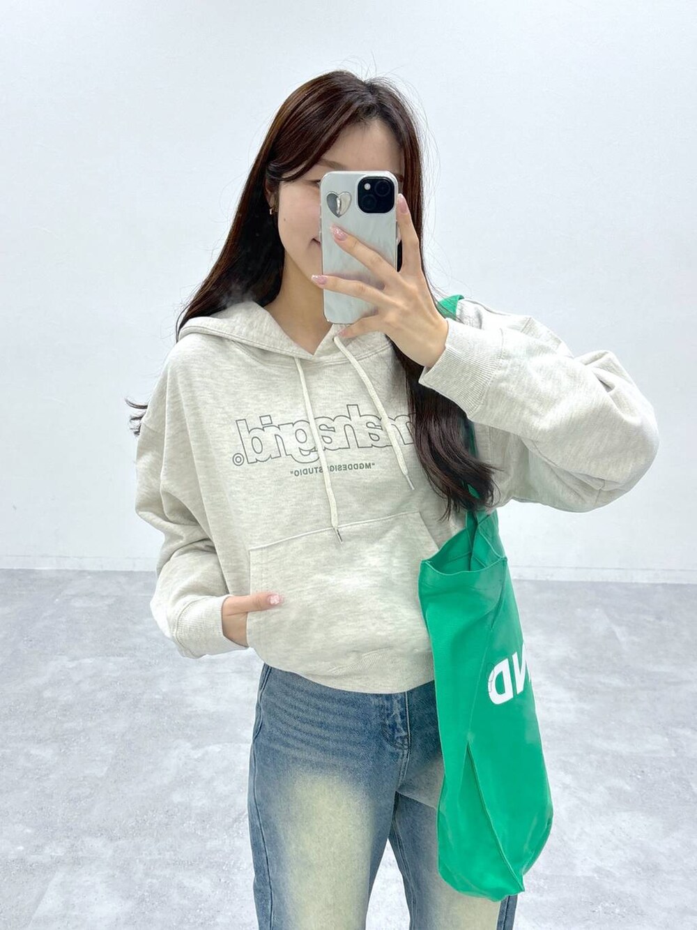 ブルー系のデニムパンツ、グリーン系のトートバッグを着用したレディースの秋コーディネートの5枚目の写真