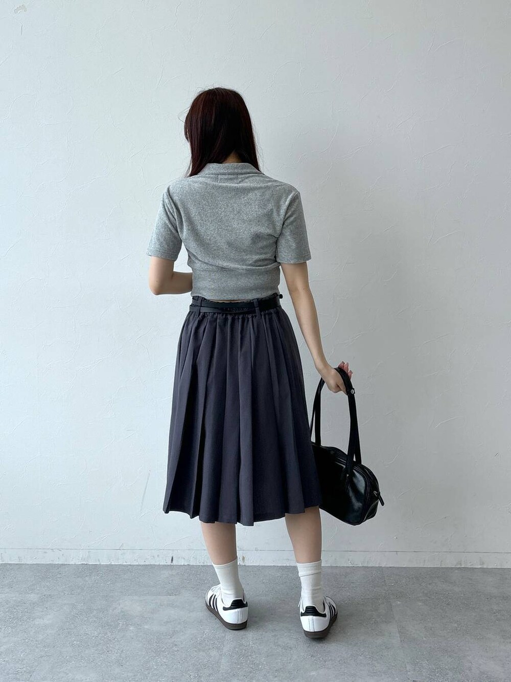 ブラック系のハンドバッグ、グレー系のスカート、グレー系のTシャツ/カットソーを着用したレディースの夏コーディネートの4枚目の写真