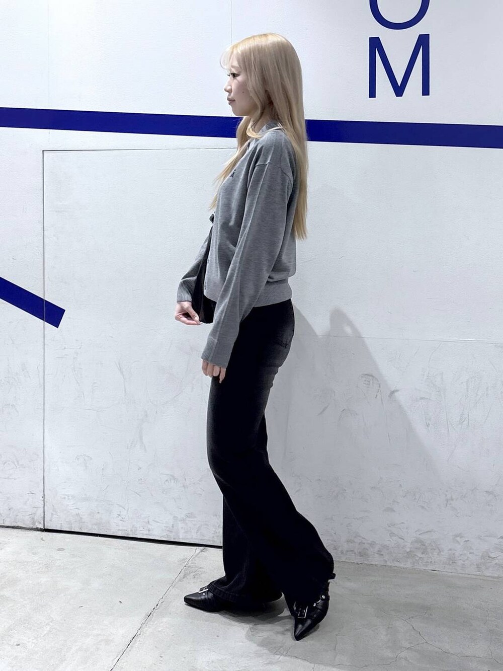 ブラック系のショルダーバッグ、ブラック系のデニムパンツ、ブラック系のパンプスを着用したレディースの冬コーディネートの3枚目の写真