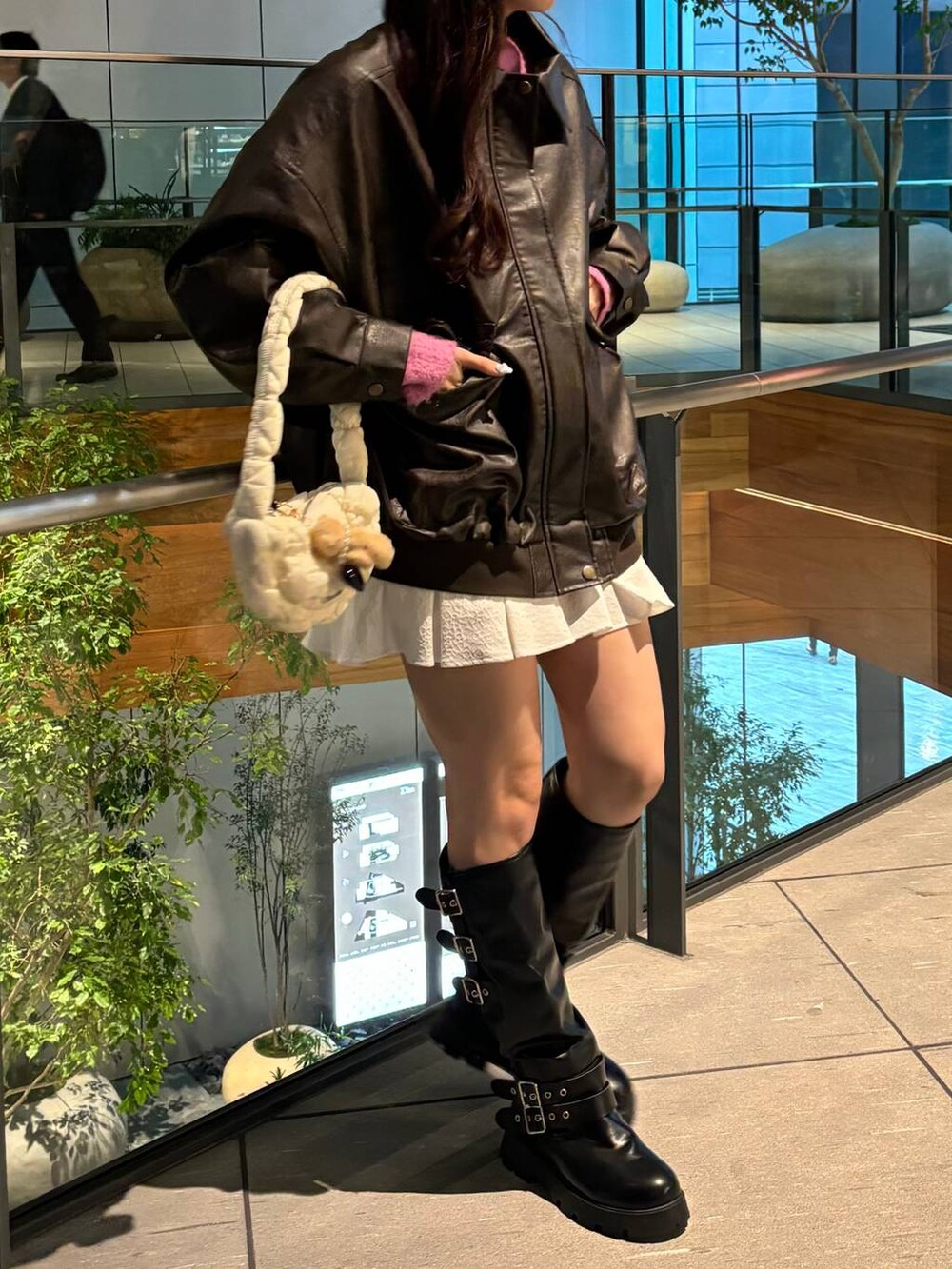 ブラウン系のライダースジャケット、ホワイト系のショルダーバッグ、グレー系のカーディガン/ボレロを着用したレディースの秋コーディネートの4枚目の写真