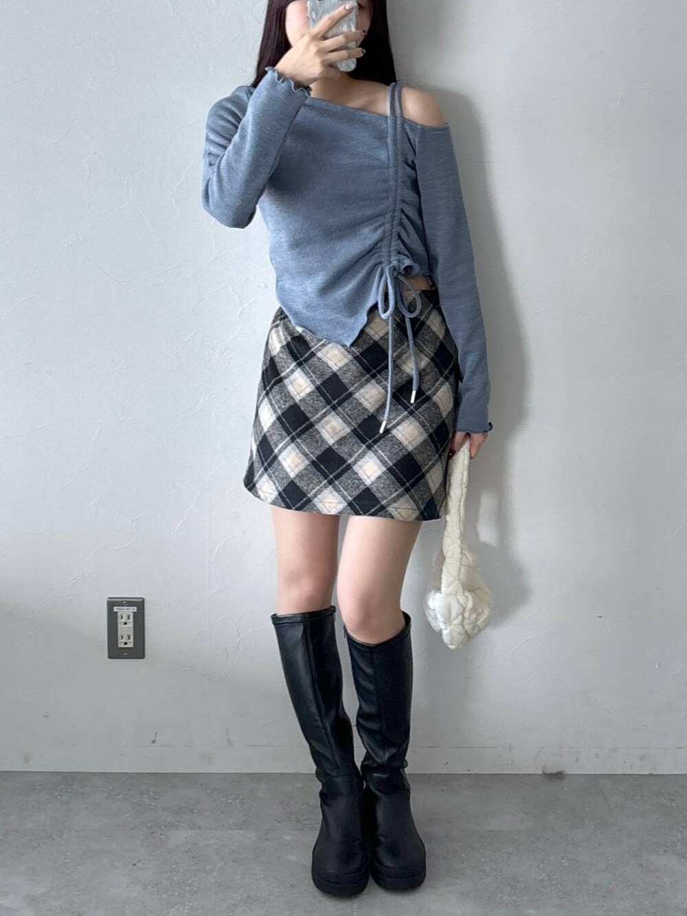 ホワイト系のショルダーバッグ、ブラック系のスカート、ブルー系のTシャツ/カットソーを着用したレディースの冬コーディネートの4枚目の写真